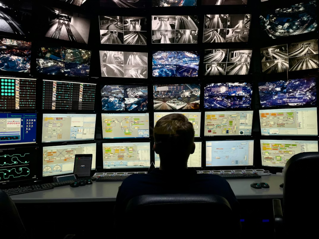 a guard monitoring CCTV cameras through a control room
