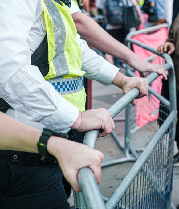 a guard controlling a crowd through barricades