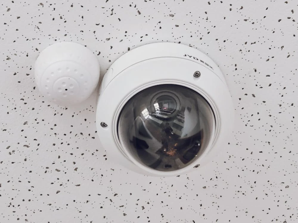 close-up of a round and white CCTV on the ceiling