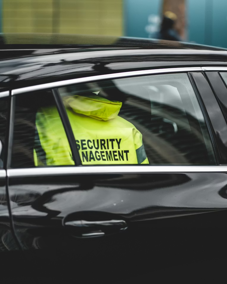 a security manager sitting in a black car