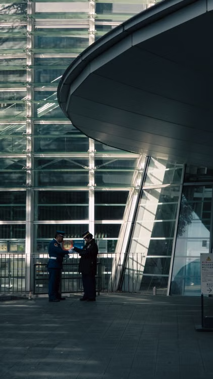 Security officer standing outside a modern commercial building entrance